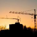 Two tower crane rentals in Alberta in front of a sunset