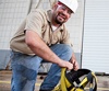 Worker checking fall protection equipment while training